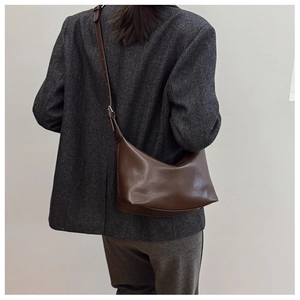 Detail of dark brown vintage hobo bag with adjustable strap and textured wool blazer