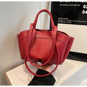 Detailed close-up of red lychee pattern leather tote bag with white contrast stitching
