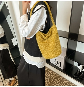 Detail of yellow plush tote bag showing soft faux fur texture and wide shoulder strap