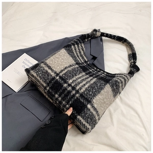 Detail of plush black and white checkered tote bag with soft faux fur texture
