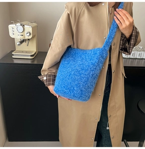 Close-up of bright blue plush faux fur shoulder bag texture with soft long-hair fibers