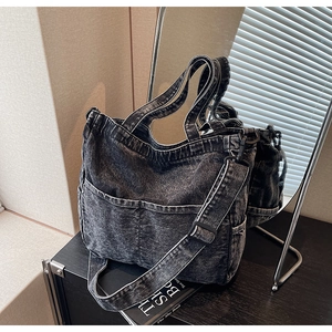 Detail of vintage gray denim tote bag showing multiple pockets and adjustable strap