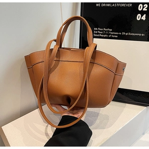 Detail shot of brown lychee grain faux leather texture on minimalist tote bag