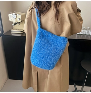Detail of bright blue plush tote bag showing soft faux fur texture on a khaki coat