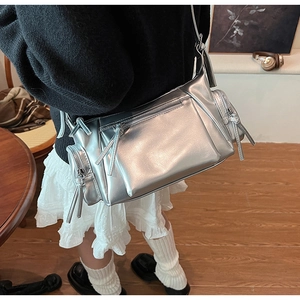 Gros plan du sac à bandoulière argenté Y2K avec fermetures éclair et cuir PU brillant