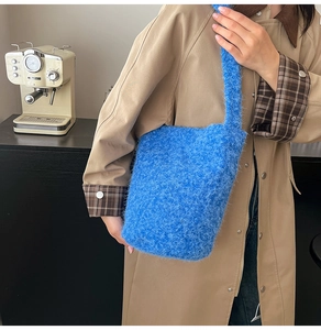 Detailed texture of fluffy bright blue faux fur tote bag on model in trench coat