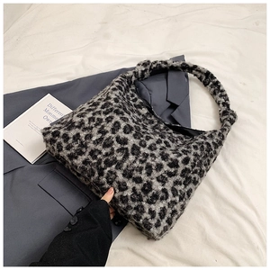 Detail of soft leopard print tote bag with knotted strap on grey blazer texture