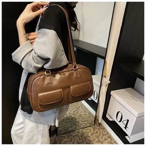 Detailed view of vintage brown leather bowling shoulder bag with two front flap pockets