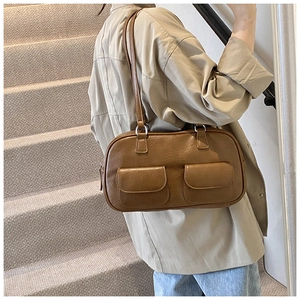 Detail view of a vintage brown leather underarm bag with double front pocket design