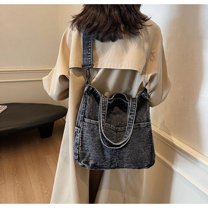Detailed back view of a large denim tote bag with wide strap and multi-pocket design