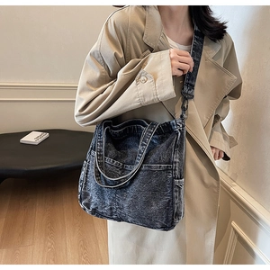 Detail of dark grey denim tote bag with contrast white stitching and multi-pockets