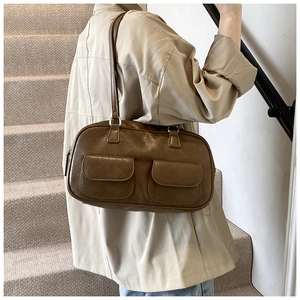 Detail showing two front flap pockets on a vintage brown textured faux leather handbag