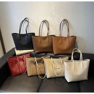 Detailed stack of Seven colorful faux leather tote bags on a sofa for business daily use