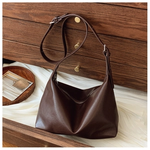 Close-up of the vintage brown leather hobo bag texture and adjustable strap detail