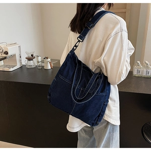 Lifestyle shot of large denim tote bag showing functional multi-pocket utility design