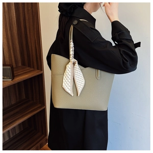 Détail du sac cabas en cuir grainé vert olive orné d'un foulard en soie à motifs cœurs