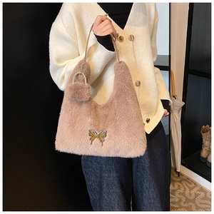 Detail of plush hobo bag with crystal butterfly buckle and faux fur pom pom charm