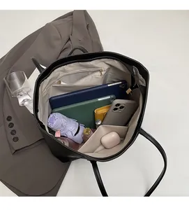 Internal view of a black tote bag showing spacious capacity for tablets and umbrellas