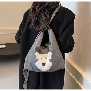 Detail of grey tote bag featuring plush Schnauzer puppy design with black strap