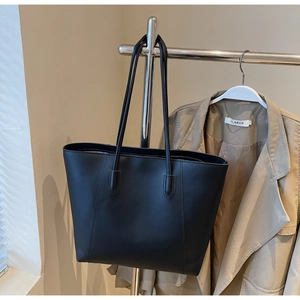 Minimalist black leather tote bag with long dual handles and vertical stitching detail