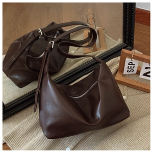 Detail of dark brown hobo bag featuring premium leather texture and silver zipper finish