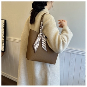 Détail du sac cabas en cuir marron avec foulard en soie géométrique à l'épaule