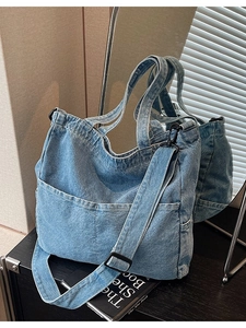 Fashionable denim tote bag with dual front pockets and adjustable strap for casual daily use