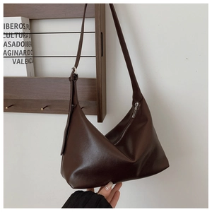 Detail of vintage dark brown crescent shoulder bag with silver hardware and adjustable strap