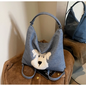Macro view of blue denim tote bag with white plush schnauzer patch and zipper detail