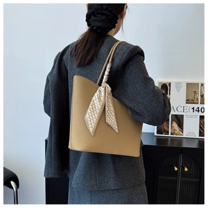 Détail du sac cabas en cuir grainé camel avec foulard en soie géométrique élégant