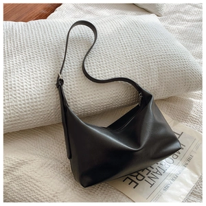 Detail of minimalist black hobo bag with adjustable strap and matte leather finish