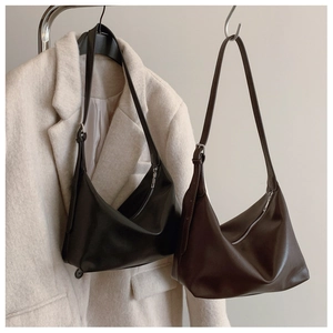 Close-up of matte leather hobo bag texture with silver metal buckles and zipper
