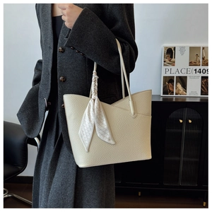 Détail du cabas crème avec texture grainée et foulard en soie à motif géométrique
