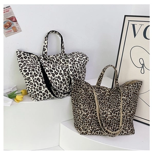 Detailed close-up of leopard print canvas tote bags in light and dark patterns