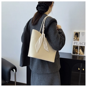Détail du sac cabas crème en cuir litchi avec ruban décoratif à carreaux noirs et blancs