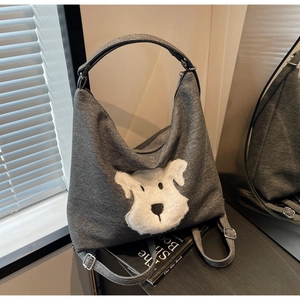 Detail view of a grey canvas tote bag featuring a cute 3D plush dog patch embroidery