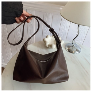 Detailed view of deep coffee hobo bag showing supple leather texture and wide strap