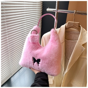 Detail of pink faux fur handbag with black butterfly patch and rhinestone buckle