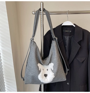 Grey knitted shoulder bag featuring a cute white faux-fur dog patch and adjustable strap