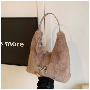 Detail view of khaki faux fur shoulder bag with silver butterfly and plush charm