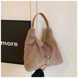 Detailed texture of mocha faux fur bag with metallic butterfly and leather strap