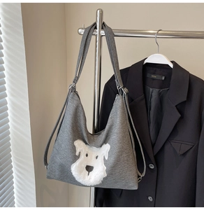 Detail of grey knitted tote bag featuring a cute white plush puppy patch embroidery