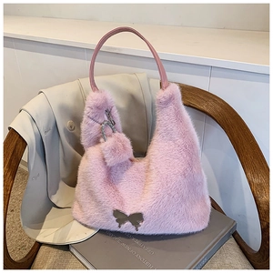 Close-up of pink faux fur plush handbag with silver butterfly buckle and fuzzy ball charm