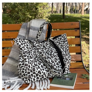 Detail of leopard print canvas tote bag on a bench showing its spacious capacity