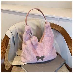 Detail of pink faux fur handbag featuring silver butterfly buckle and soft plush texture