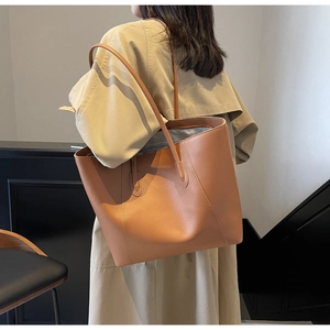 Detail of tan faux leather tote bag showing sturdy stitching and long shoulder straps