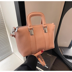 Vue détaillée du sac à main plissé rose avec ferrures argentées et poignée lisse
