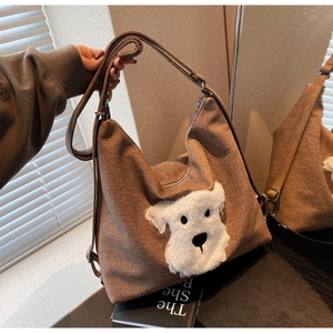 Close-up of brown canvas tote featuring a plush Schnauzer patch and adjustable straps