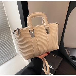 Vue détaillée de la texture à rayures verticales sur un sac seau bandoulière beige
