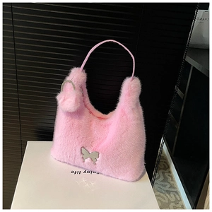 Detail of pink plush faux fur handbag with silver butterfly charm and soft fuzzy texture